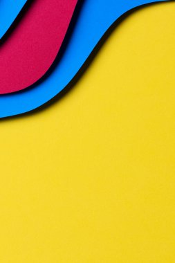 Soyut renkli kağıt dokusu arkaplanı. Asgari kağıt, geometrik şekil katmanları ve sarı arkaplanda açık mavi ve kırmızı renkli çizgilerle stil kompozisyonu keser. Üst görünüm.