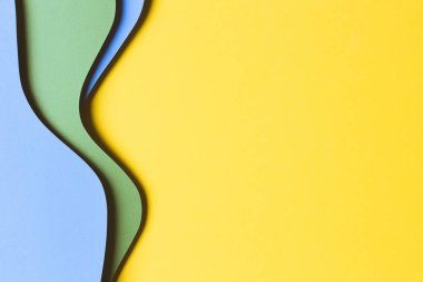 Soyut renkli kağıt dokusu arkaplanı. Asgari kağıt, geometrik şekil ve çizgilerin sarı, açık mavi ve yeşil renkli katmanlarını kesiyor. Üst görünüm, alanı kopyala