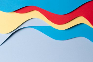Soyut renkli kağıt dokusu arkaplanı. Asgari kağıt geometrik şekil ve çizgilerin kırmızı, sarı ve açık mavi renkleri ile kesim stili bileşimi. Üst görünüm.