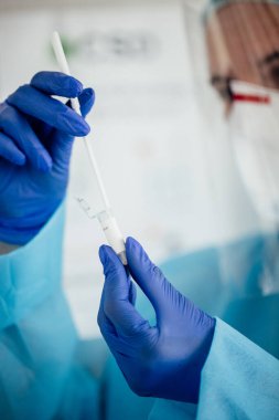 Kadın doktor elinde kovid 19 koronavirüs aşısı olan bir tüp tutuyor. 