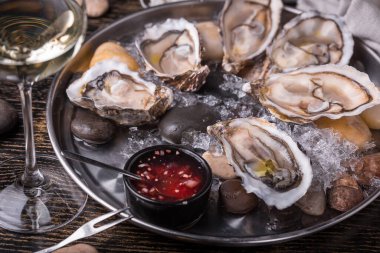 Buzlu balık restoranının soslu olduğu bir tabakta istiridye yemeye hazır.