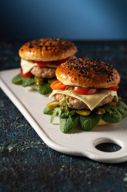 Servis panosunda pirzola ile iki hamburger, mavi arkaplan, dikey format