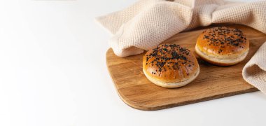 Tahta üzerinde susamlı hamburgerler beyaz arka planda, metin için yer var.