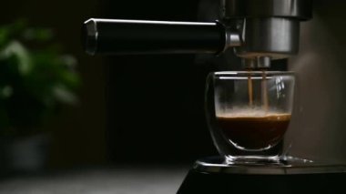 Kahve makinesi, kahve hazırlama, taze demlenmiş aromatik içeceği şeffaf bir fincana dökme süreci.