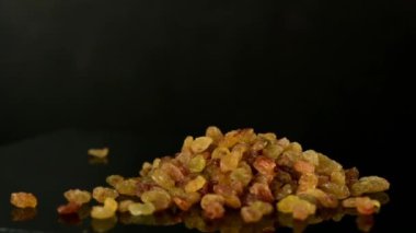 Masaya düşen altın kuru üzümler, yakın plan, masa dönüyor, yavaş çekim video