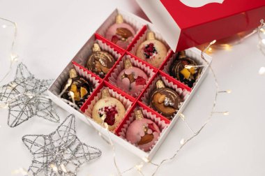 Yeni yıl kutlaması, el yapımı çikolatalar, beyaz arka planda Noel hediyeleri ve tel örgü yıldızları.