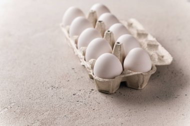 Chicken white eggs in a pan on a light background, empty space for text, rear lateral light