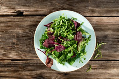 Taze otların salata karışımı, roka, İsviçre pazısı, tarenle 'de ahşap bir arka planda ıspanak, serhu manzarası