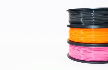 3D baskı için PLA plastiği. Çevre dostu plastik makaralar, beyaz arka planda sarı ve pembe renkler