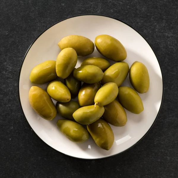Grüne Eingelegte Oliven Auf Dunkelgrauem Hintergrund Quadratisch Ansicht Von Oben — Stockfoto