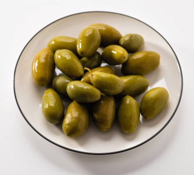 büyük yeşil zeytinler beyaz tabakta, makro, kare biçiminde