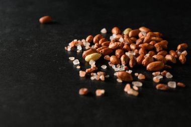 yer fıstığı, kuru yer fıstığı, Himalaya kaba tuzu koyu gri arka planda, mesaj için boş alan