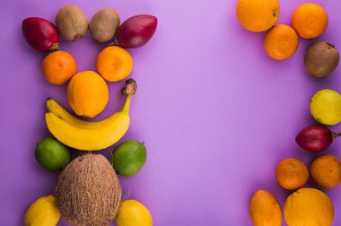 Citrus meyvesi ve muz, kakao, mor arka planda kivi. Türlü narenciye ve tamarillo. Şarap masasında kakao ve diğer meyveler. Metnin için alanı kopyala. Taze Brekker için tatlı çeşitleri. 