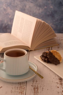 Sabah rahatlamasının harika bir fotoğrafı sıcak renklerde yapılır. Bir fincan çay ve kitap güne en iyi başlangıçtır. Romantik bir ruh hali sağlığınızı ve sağlığınızı geliştirecektir. Güneşin doğuşunun tadını çıkar.