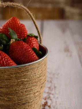 Bu atmosferik çilek fotoğrafı sıcak ve güneşli renklerde yapılır. Meyve kovası sağlık, tazelik ve orman belirtileriyle dolu bir bahçenin aromalarıyla dolup taşıyor. Orman lezzetlerinin tadını çıkar..