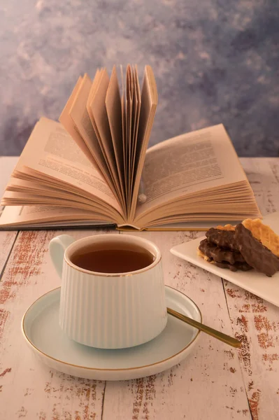 暖かい色で朝のリラクゼーションの素晴らしい写真が行われます お茶と本のカップは一日の始まりです ロマンチックな気分はあなたの幸福と健康を向上させます 日の出を楽しむ — ストック写真