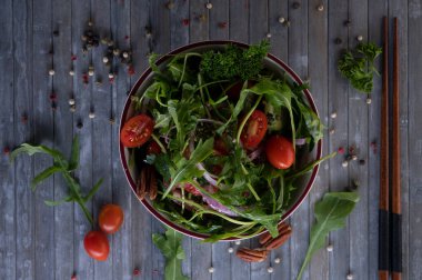 Roket salatası, kiraz domatesleri ve soğandan yapılmış hafif kahvaltı salatası. Fotoğraf yüksek çözünürlüklü HD ile çekilmiş. Salatanın en üst görüntüsü..