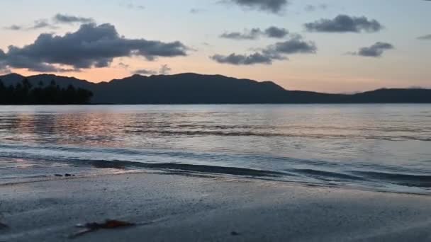 4K视频显示了黄豆海背景下的高山落日 太阳落在山后 在云中 海水反映了落日的光芒 — 图库视频影像