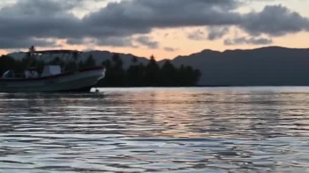 4Kビデオは大西洋を背景に山の中で日没を示しています 太陽は山の後ろに落ち 雲の中にある 海水は沈みゆく太陽の輝きを反射する — ストック動画