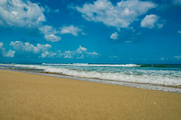 Dominik Cumhuriyeti 'nin ön planında kumlu bir plajın fotoğrafı. Bu resim Atlantik Okyanusu 'ndan gelen muhteşem kumları ve parlak mavi gökyüzünü açıkça gösteriyor, bir ufuk çizgisi oluşturuyor..