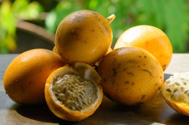 Fotoğraf tropik bölgelere özgü egzotik bir meyveyi gösteriyor. Tropikal meyveye granadilla ya da tatlı tutku meyvesi denir. Granadilla turuncu renkli ve içinde bir sürü tohum var..