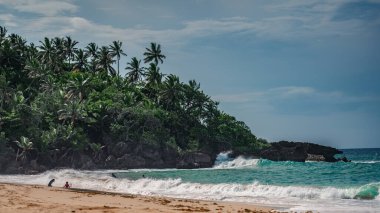 Dominik Cumhuriyeti 'nin ön planında kumlu bir plajın fotoğrafı. Bu resim Atlantik Okyanusu 'ndan gelen muhteşem kumları ve parlak mavi gökyüzünü açıkça gösteriyor, bir ufuk çizgisi oluşturuyor..