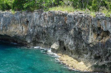 Fotoğrafta Atlantik Okyanusu kayalık bir sahile sahip. Egzotik adanın sahilinde birçok kaya ve mağara var. Kayalık arazi ve deniz harika bir tatil yeridir..