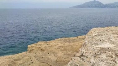 Procida, Campania, İtalya - 2 Ekim 2021: Punta Solchiaro kıyılarına bir göz atma ile Ischia Adası