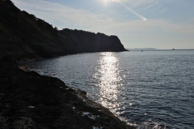 Procida, Campania, İtalya - 1 Ekim 2021: Rocce del Faro di Punta del Pioppeto 'dan Capo Bove' a uzanan uçurumun arka aydınlatma panoramik görüntüsü