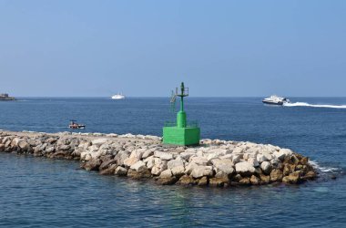 Procida, Campania, İtalya - 30 Eylül 2021: Marina Grande limanının dalgakıranındaki yeşil deniz feneri