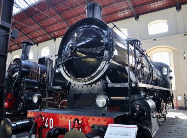 Portici, Campania, İtalya - 27 Ağustos 2021: Pietrarsa Ulusal Demiryolu Müzesi 'nin A Pavyonu' nda buharlı lokomotifler sergileniyor