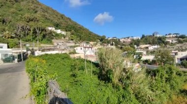 Ischia, Campania, İtalya - 14 Mayıs 2022 Via Quercia üstgeçidinde görülen 270 numaralı eyalet yolunun yanındaki küçük bahçede Benvenuti ad Ischia bitkileriyle birlikte yazılmıştır.