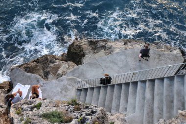 Praiano, Campania, İtalya - 1 Ekim 2022 Marina di Praia kıyı şeridi boyunca kayalıklarda dinlendirici anlar