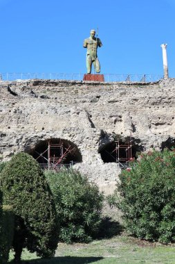 Pompeii, Campania, Italy - October 14, 2021: The colossal bronze sculpture of Daedalus made in 2016 by the Polish sculptor Igor Mitoraj and placed in front of the Temple of Venus near Porta Marina clipart