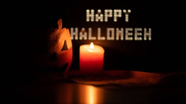 Cadılar Bayramı Parti Gecesi için dekorasyon Baş Jack Balkabağı Çantası Yanan Mum ve Tablet ile Kara Arkaplanda Mutlu Cadılar Bayramı