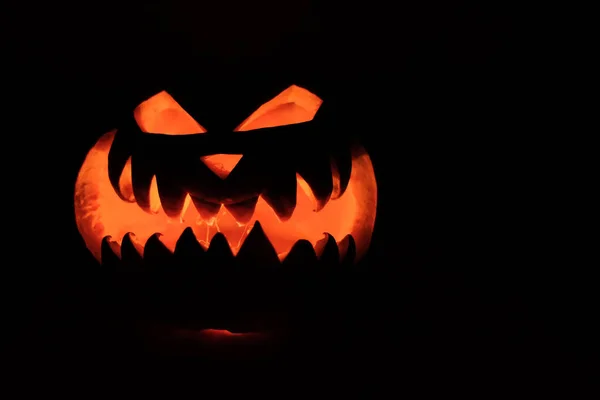 Cabeça de Halloween Jack abóbora com sorriso assustador e velas ardentes para dentro para a noite de festa em fundo preto — Fotografia de Stock