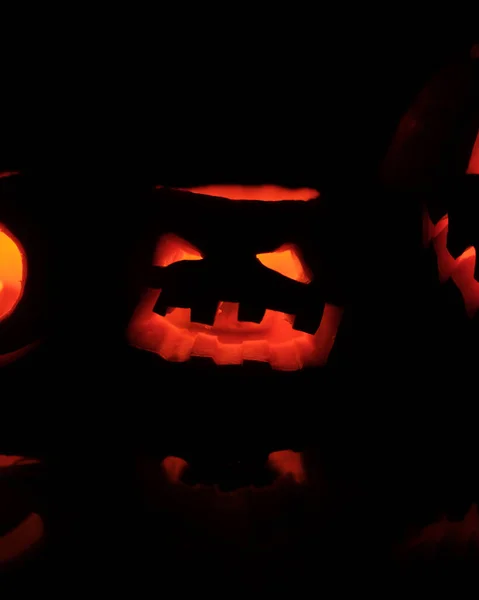 Cabeça de Halloween Jack abóbora com sorriso assustador e velas ardentes para dentro para a noite de festa em fundo preto — Fotografia de Stock