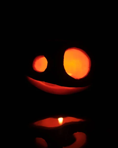 万圣节前夕头像杰克南瓜，带着恐怖的微笑和燃烧的蜡烛，在黑色背景下的派对之夜 — 图库照片