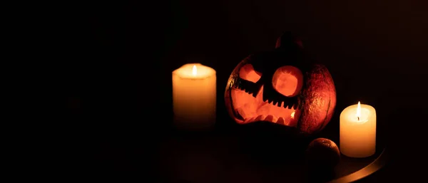 Head Jack tök ijesztő mosollyal és égő gyertyák fél éjszaka a fekete háttér, Halloween koncepció — Stock Fotó