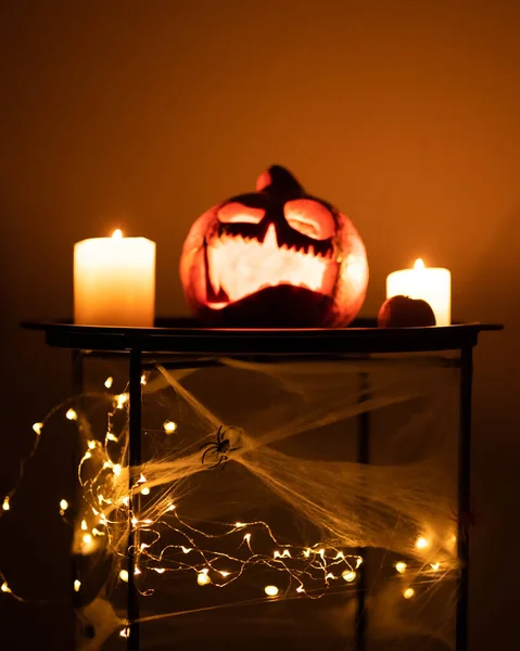 Kopf Jack Kürbis mit gruseligem Lächeln und brennenden Kerzen für die Partynacht auf schwarzem Hintergrund, Halloween-Konzept — Stockfoto