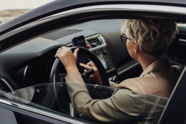 İş Kadını Araba Kullanırken Akıllı Telefon Kullanıyor, Yan Pencereden Görünüm