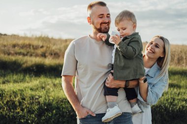 Dışarıda Mutlu Genç Aile portresi, Anne ve Baba ve Küçük Oğulları Eğleniyor