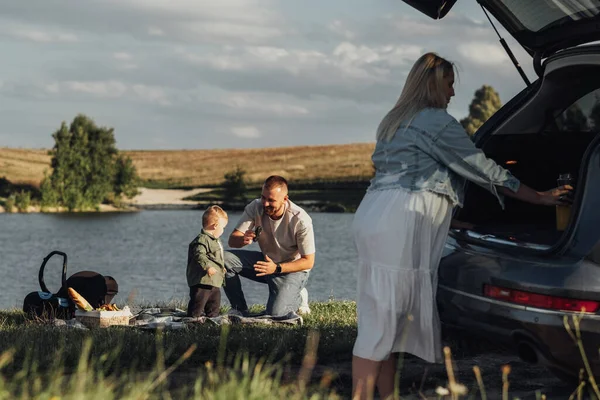 Happy Family Weekend Concept, Mor och far med Toddler Son njuter av picknick utomhus på en bilresa — Stockfoto