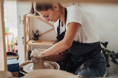 Potter İşletme Ustası, Stüdyoda Çömlek Tekerleği Üzerinde Clay Pot Yaratan Beyaz Kadın