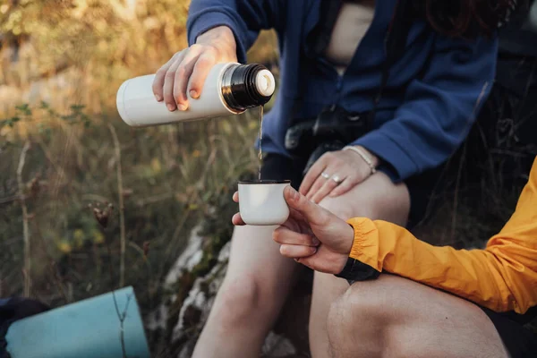 Zwei Wanderer machten während der Wanderung Halt, um heißen Tee aus der Thermoskanne zu trinken — Stockfoto