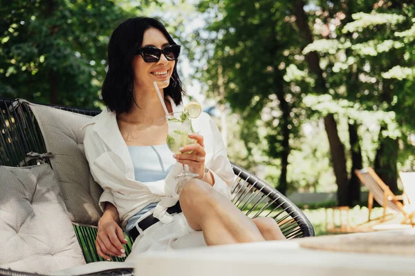 Mladá bruneta žena relaxační a pitný koktejl zatímco sedí na terase restaurace venku v létě slunečný den — Stock fotografie