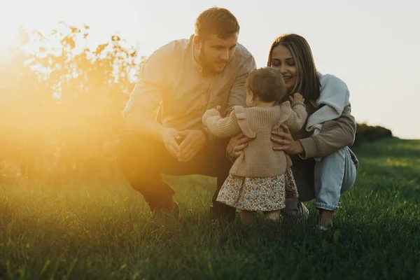 Portrait of Happy Young Caucasian Family, Mother and Father with their Baby Daughter Outdoors at Sunset — Stock Photo, Image