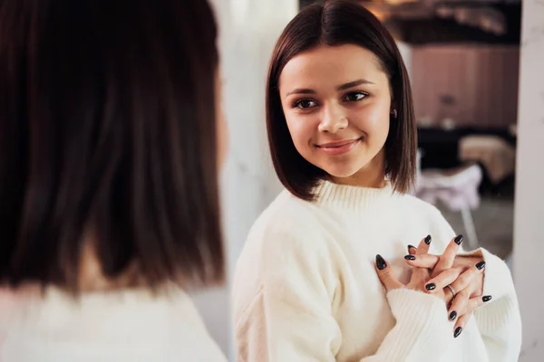Jeune femme caucasienne Admirant elle-même dans le miroir dans le couloir du salon de beauté — Photo