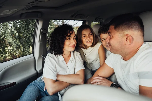 Mère et père avec deux enfants adolescents lors d'un voyage de fin de semaine, heureux quatre membres de la famille voyageant en voiture minibus — Photo
