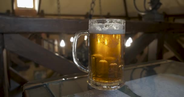 Mok van licht bier staande op de vintage tafel in de oude taverne, glas gevuld met Lager Ale in de Pub — Stockvideo